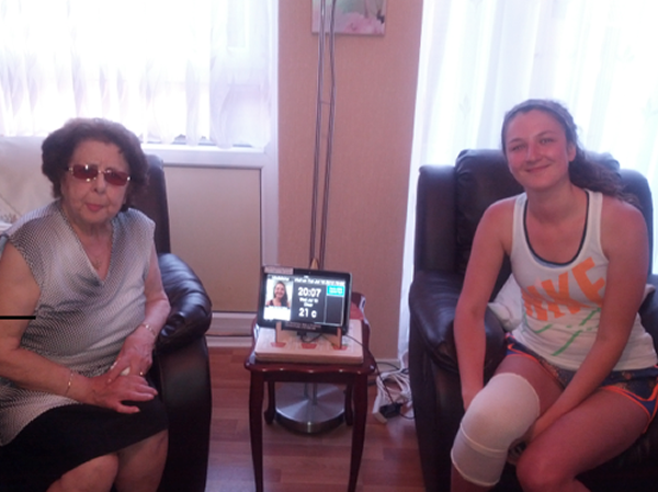 A coach and her runner with the GoodGym app on a tablet during a visit.